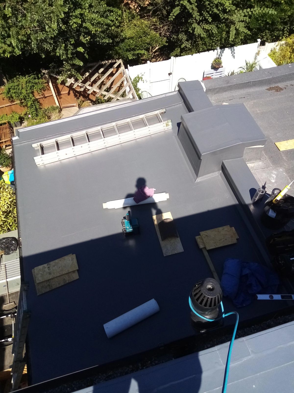 A person applying waterproof coating on a surface using a roller