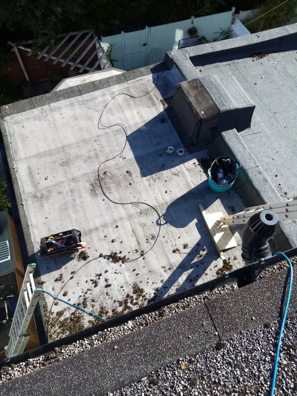 Flat roof with black waterproofing material and tools for repair work